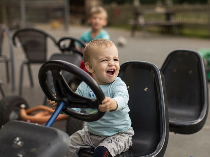 Ein Kleinkind sitzt auf einem Catkart.